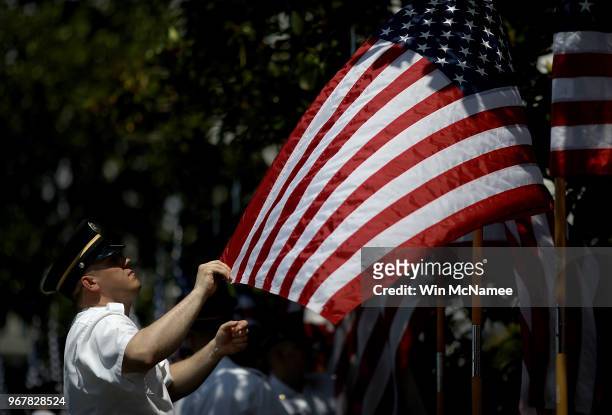 Members of a U.S. Army honor guard team set American flags in place for a "Celebration of America" event on the south lawn of the White House June 5,...