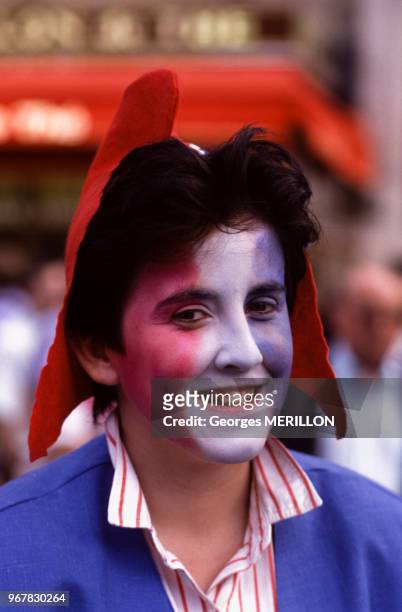 Spectateur au visage peint aux couleurs du drapeau français lors de la parade La Marseillaise de Jean-Paul Goude sur l'avenue des Champs-Elysées le...