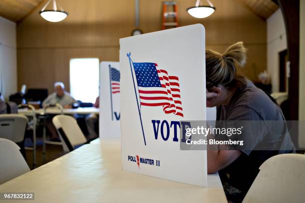 Voter fills out a ballot behind a privacy screen at a polling location in Davenport, Iowa, U.S., on Tuesday, June 5, 2018. Even as Donald Trump...