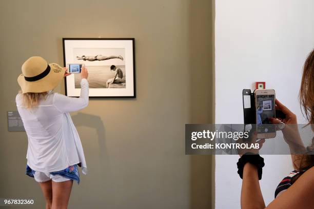 Visitors take picture of the exhibition 'L'Immagine Invisibile' at Archaeological Museum in Paestum southern Italy. The exhibition shows paintings,...