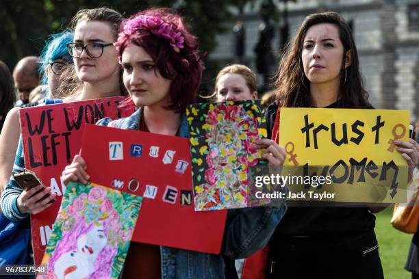 Pro-choice campaigners hold placards outside the Houses of Parliament during a demonstration to urge the Government to extend the same laws on...