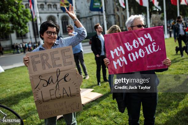 Pro-choice campaigners hold placards outside the Houses of Parliament during a demonstration to urge the Government to extend the same laws on...