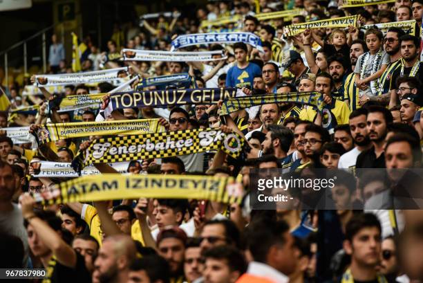 Fenerbahce supporters holds scarves during a gathering with the newly elected Fenerbahce chairman at the Ulker Stadium in Istanbul on June 5 in...