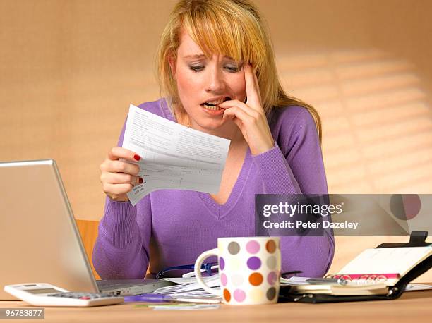 teenager showing anxiety holding bill - calculator tax forms stockfoto's en -beelden