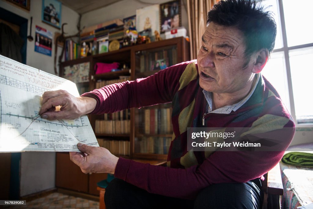 Sharkhuu Tsedenish, 61, a retired meteorologist, explains a...