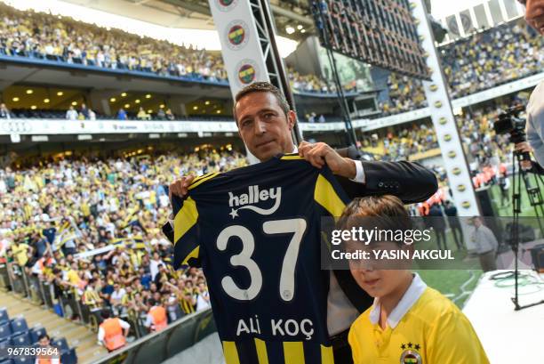 Turkish businessman and newly elected Fenerbahce chairman Ali Koc poses with a jersey to his name during a gathering at the Ulker Stadium in Istanbul...