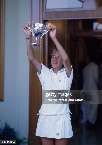 Natasha Zvereva of the Soviet Union lifts the trophy after defeating Julie Halard of France in the Junior Girls' Singles Final in the Wimbledon Lawn...