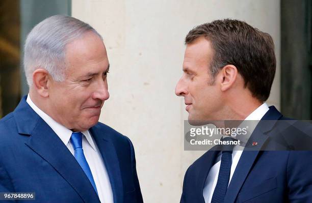 French President Emmanuel Macron accompanies Israeli Prime Minister Benjamin Netanyahu after their meeting at the Elysee Presidential Palace on June...