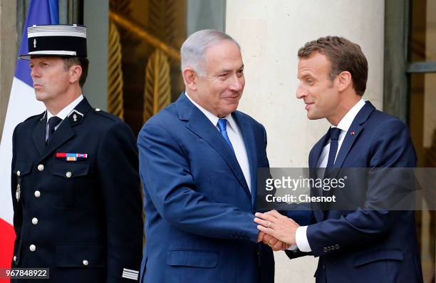 French President Emmanuel Macron accompanies Israeli Prime Minister Benjamin Netanyahu after their meeting at the Elysee Presidential Palace on June...