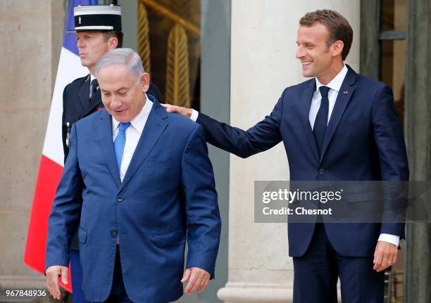 French President Emmanuel Macron accompanies Israeli Prime Minister Benjamin Netanyahu after their meeting at the Elysee Presidential Palace on June...