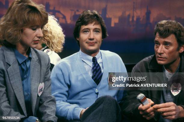 Nathalie Baye, Patrick Sabatier et Johnny Hallyday sur un plateau de télévision pour les Restaurants du Coeur le 26 janvier 1986 à Paris, France.