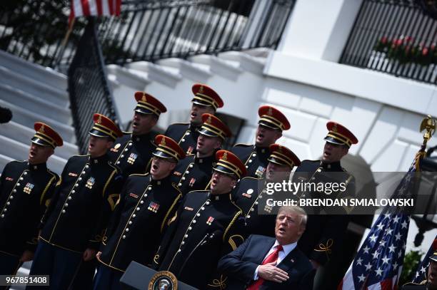 President Donald Trump sings the US National Anthem in the "Celebration of America" at the White House in Washington, DC, on June 5, 2018. - Trump's...