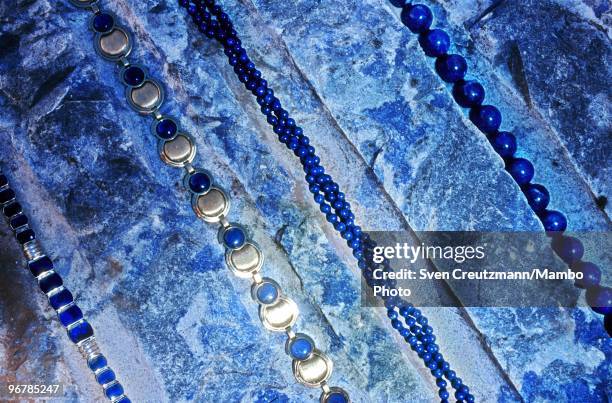 Jewellery chains made of Lapis Lazuli lie on a raw Lapis Lazuli rock in the Flores de Los Andes mine, located at 3,700 meter high in the Andes, on...