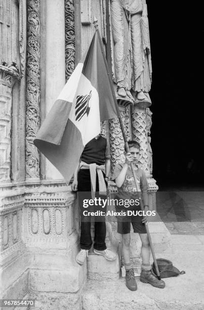 Jeune scout tenant un drapeau libanais lors du départ du pèlerinage traditionnel de Notre-Dame de Paris à Chartres le 17 mai 1986 à Paris, France.