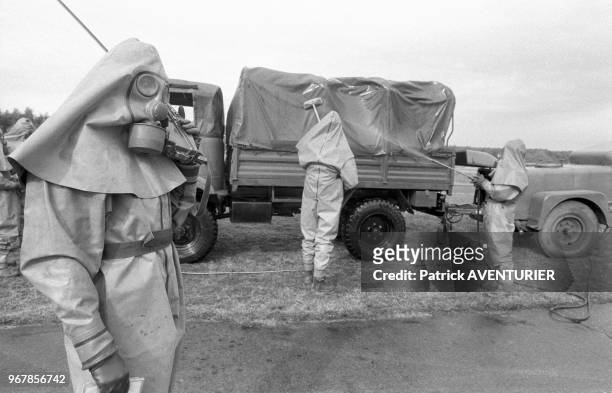 Soldats en tenue de protection lors d'un exercice de l'armée de l'air à Chalons-Vatry le 28 mars 1984, France.