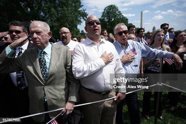 Event guests listen to the national anthem during a 'Celebration of America' event on the south lawn of the White House June 5, 2018 in Washington,...