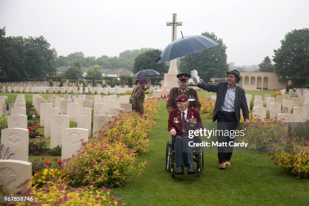 Ray Shuck who was a paratrooper on D-Day and was later shot in the head by a German sniper sits visits cemetery close to the church in Ranville where...