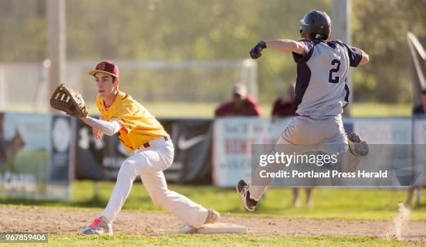 Yarmouth senior James Waaler makes it safely to first right before Cape Elizabeth junior Alex Riggle catches the ball during the seventh inning of...