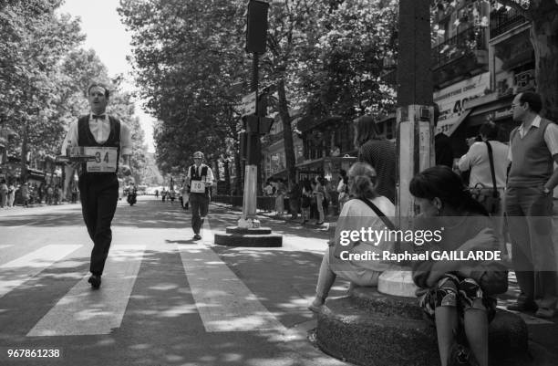 Participants à la course des garçons de café, tenant son plateau en équilibre, le 19 juin 1988, Paris, France.