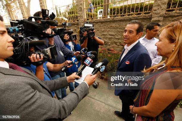 Democratic candidate for governor Antonio Villaraigosa, with wife Patty Villaraigosa at his side, talks to media after submitting his completed mail...