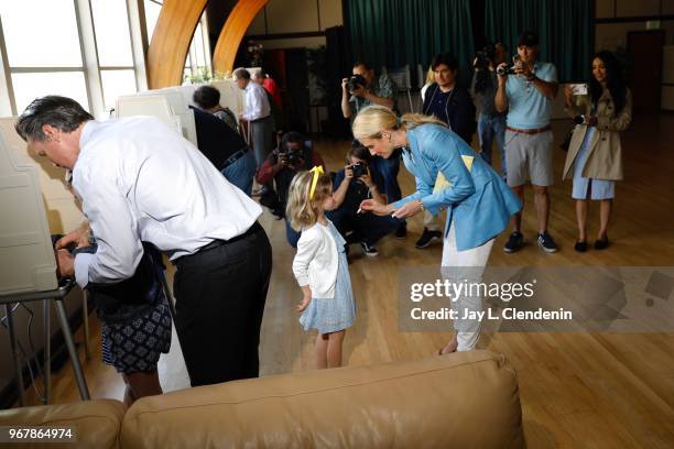 Democratic Lt. Gov. Gavin Newsom marks his ballot with daughter Montana while his wife Jennifer Siebel Newsom tries to occupy daughter Brooklynn at...