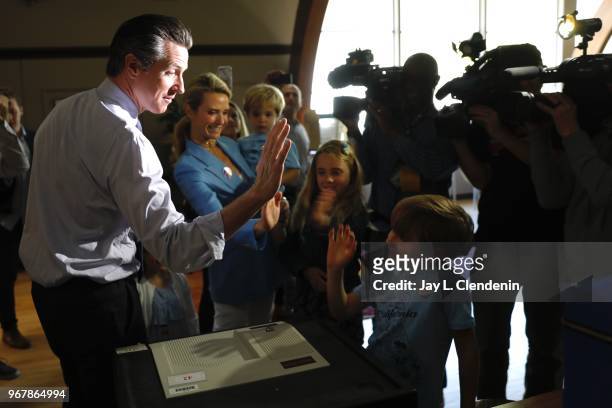 Democratic Lt. Gov. Gavin Newsom gets a high-five from his son Hunter after casting his ballot in the primary election with his wife, Jennifer Siebel...
