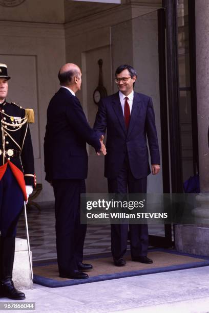 Valéry Giscard d'Estaing serre la main de Jean-Louis Bianco sur le perron du palais de l'Elysée le 29 juin 1988 à Paris, France.