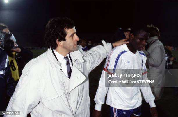 Michel Platini, sélectionneur de l'équipe de France, avec Basile Boli à la fin du match de football Yougoslavie-France le 19 novembre 1988 à...