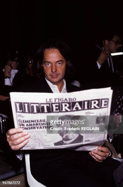 Gonzague Saint-Bris lit Le Figaro littéraire lors d'un défilé de mode le 24 octobre 1988 à Paris, France.