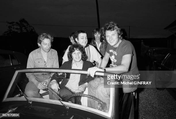 Johnny Hallyday avec Serge Gainsbourg, Jane Birkin, Coluche, Gérard Lenorman, Nathalie Delon dans la 'Rosengard' modèle 1939 qu'il a reçue en cadeau,...
