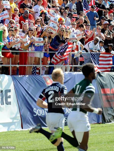 Fans of the United States cheer as the team, including Marco Barnard, takes the pitch for a game against Guyana during the IRB Sevens World Series at...