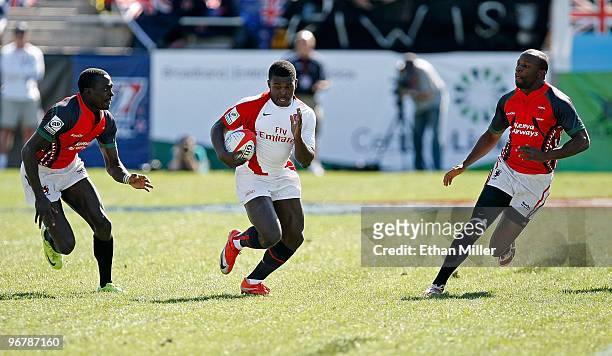 Christian Wade of England runs between Collins Injera and Lavin Asego of Kenya during the IRB Sevens World Series at Sam Boyd Stadium February 14,...