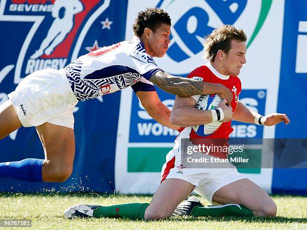 Aaron Bramwell of Wales scores a try as he is tackled by Mikaele Pesamino of Samoa during the IRB Sevens World Series at Sam Boyd Stadium February...