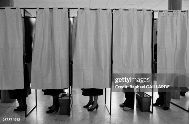 Electeurs dans les isoloirs lors du scrutin législatif le 16 mars 1986 à Paris, France.