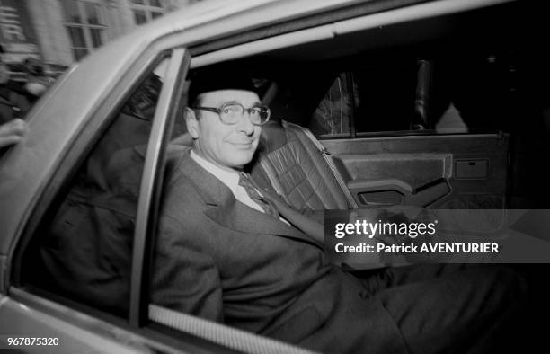 Le maire de Paris Jacques Chirac à l'arrière de sa voiture officielle entrain de fumer une cigarette le 20 mars 1986 à Paris, France.