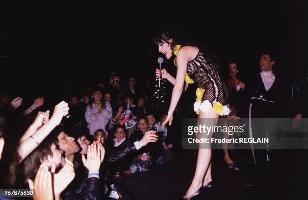 La chanteuse Lio sur la scène de l'Olympia serre la main des spectateurs le 20 mai 1987 à Paris, France.