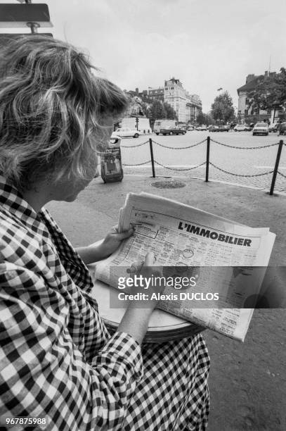 Une jeune femme recherche un appartement via les petites annonces d'un journal, Paris le 23 juin 1987, France.
