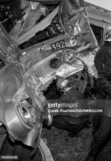 Des pompiers recherchent des survivants après la collision entre un train de voyageurs et un RER à Issy-les-Molineaux le 24 décembre 1987, France.