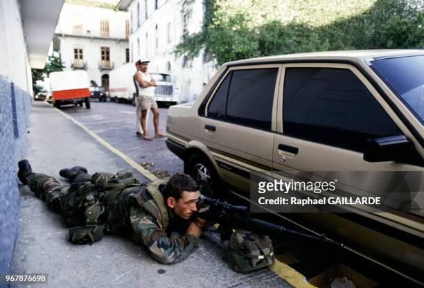 Soldat américain allongé aux côtés d'une voiture, fusil-mitrailleur en main, à Panama le 26 décembre 1989.