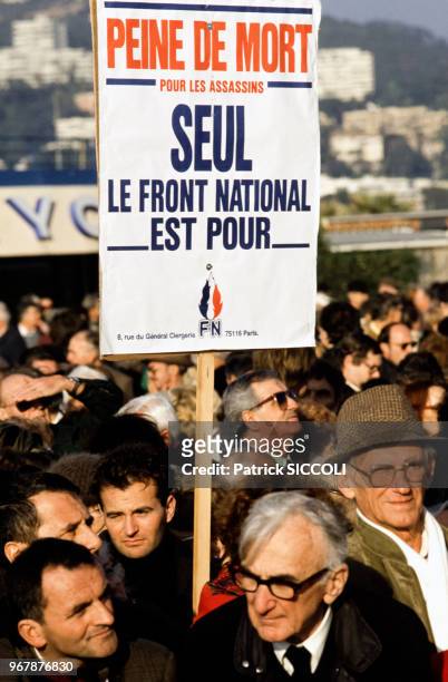 Militants du Front national portant une affiche pour la peine de mort, à Cannes, France le 13 janvier 1990.