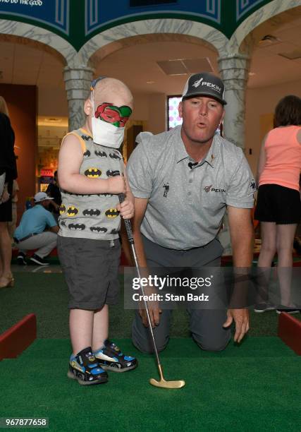 Points plays putt-putt with a young patient from St. Jude Children's Hospital during Golf-A-Round prior to the FedEx St. Jude Classic at TPC...