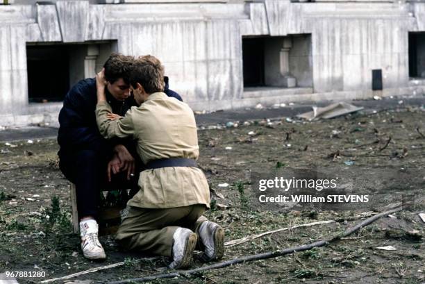 Combattant réconfortant un jeune homme, à Bucarest, Roumanie le 25 décembre 1989.