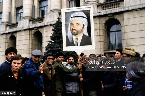 Hommes brandissant la caricature de Caeusescu barbu et portant le turban iranien, à Bucarest, Roumanie le 25 décembre 1989.