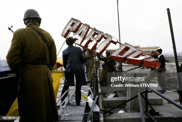 Destruction des symboles communistes sur le toit de m'immeuble de Comité central, à Bucarest, Roumanie le 26 décembre 1989.