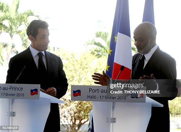 French President Nicolas Sarkozy looks at Haitian President Rene Preval speak during a joint press conference on the grounds of the Presidential...