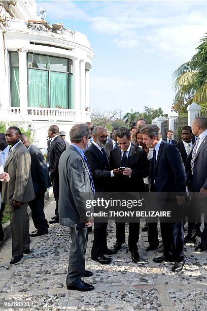 Haitian President Rene Preval shows French President Nicolas Sarkozy his mobile phone before attending a joint press conference on the grounds of the...