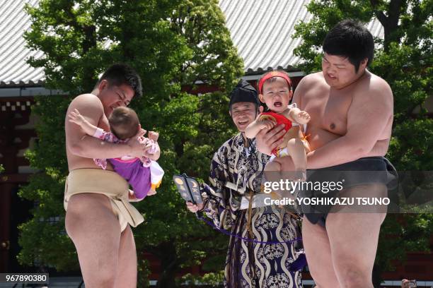 Bébés tenus par des lutteurs sumo s'affrontent en criant le plus fort possible dans le temple Sensoji à Tokyo le 30 avril 2017, Japon. Les parents...