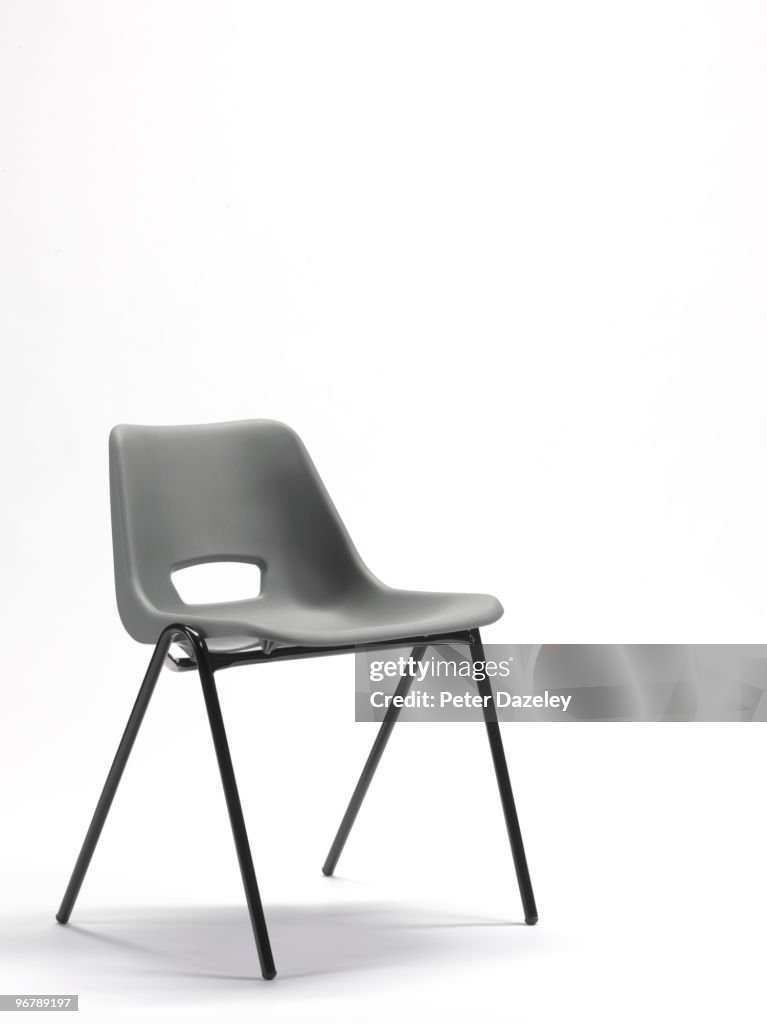 Grey plastic stacking chair with copy space