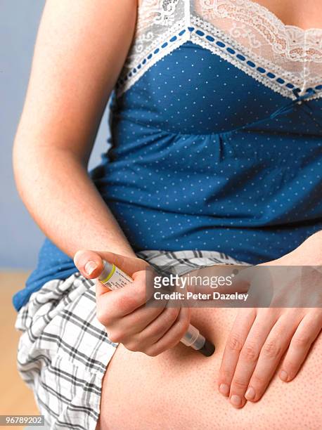 teenager injecting with epipen after an attack - adrenalina fotografías e imágenes de stock