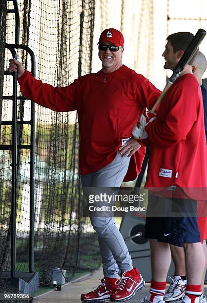 Hitting coach Mark McGwire talks with infielder David Freese in the batting cages on his first day in uniform during Spring Training on February 17,...